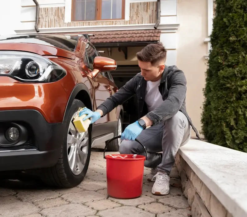 Lavage auto à domicile Castelnau-de-Guers : professionnel intervenant sur un véhicule
